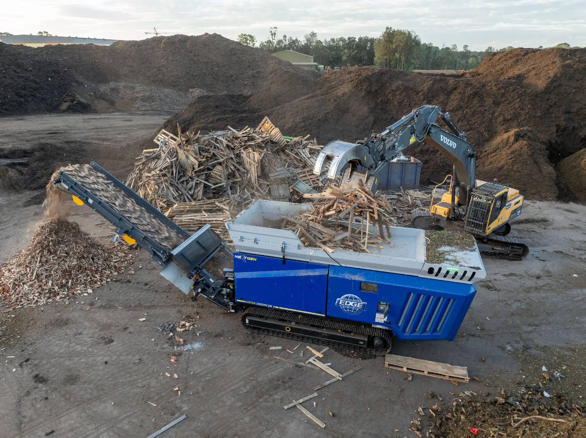 EDGE VS420 slow speed shredder processing timber with Volvo excavator on site